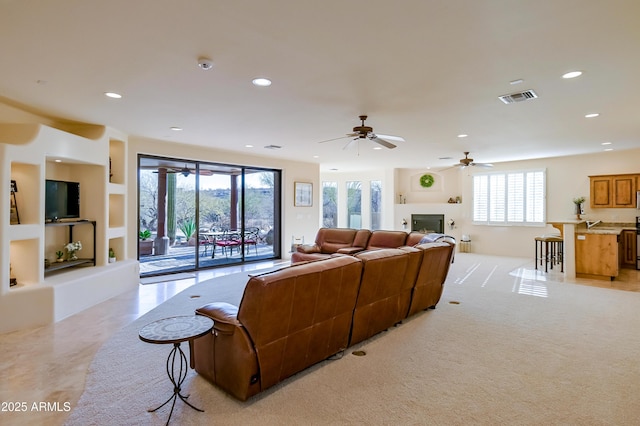 living room featuring recessed lighting, visible vents, light carpet, and a ceiling fan