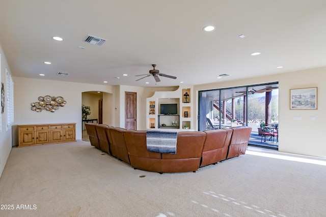 living area featuring visible vents, recessed lighting, arched walkways, ceiling fan, and light carpet