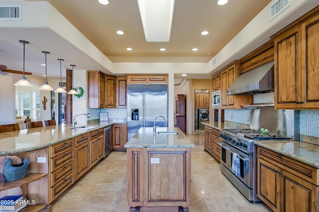 kitchen featuring built in appliances, ventilation hood, visible vents, and a sink