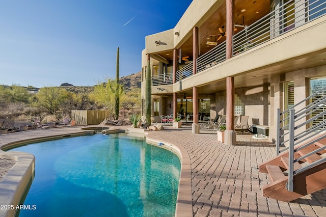 view of swimming pool with a patio area, a ceiling fan, fence, and a pool with connected hot tub