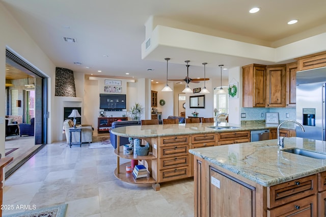 kitchen featuring a sink, stainless steel appliances, brown cabinets, and open shelves