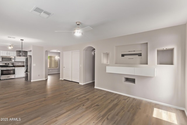 2438 W Via Dona Rd, Phoenix, AZ 85085 - unfurnished living room featuring ceiling fan, arched walkways, baseboards, and dark wood-type flooring