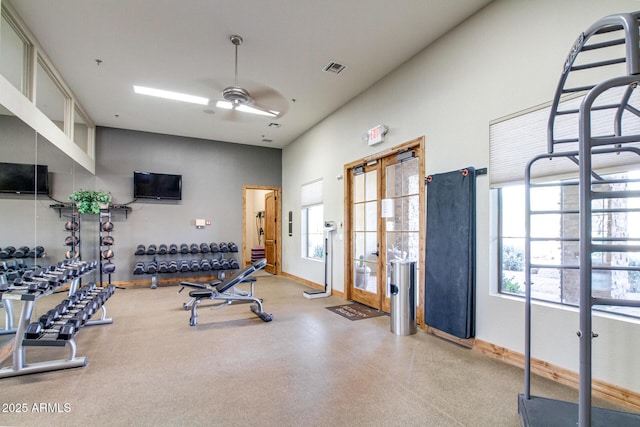 exercise area featuring a high ceiling, visible vents, baseboards, and ceiling fan