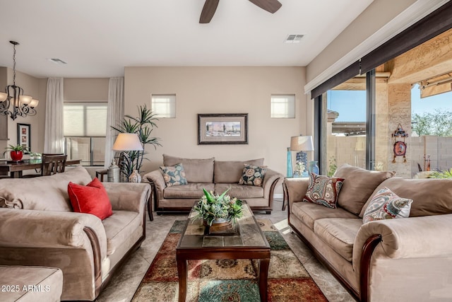 living room with visible vents and ceiling fan with notable chandelier