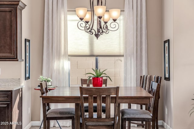 dining room with a chandelier and baseboards