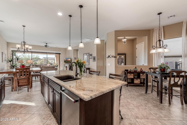 kitchen with light stone counters, visible vents, a sink, pendant lighting, and dishwasher