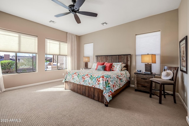 carpeted bedroom with visible vents, baseboards, and ceiling fan