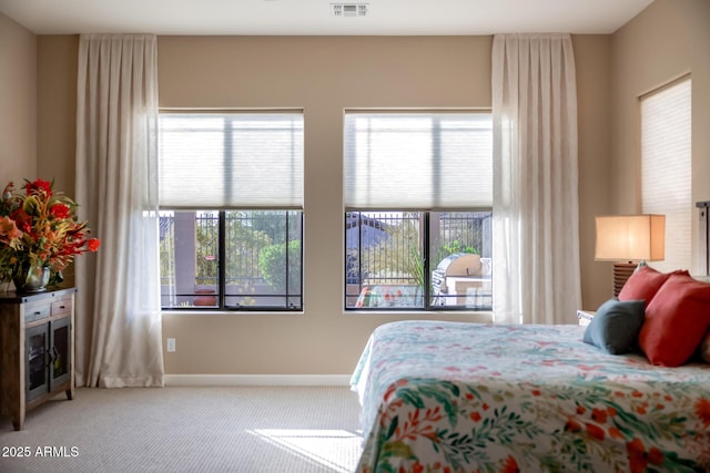 carpeted bedroom featuring visible vents, multiple windows, and baseboards