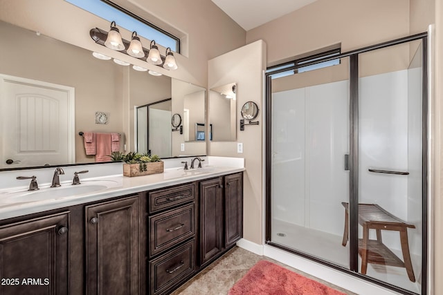 full bath with double vanity, a stall shower, and a sink