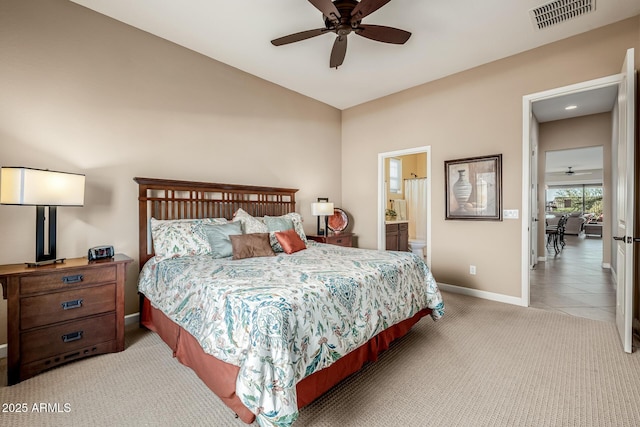 bedroom featuring visible vents, baseboards, light carpet, ensuite bathroom, and a ceiling fan