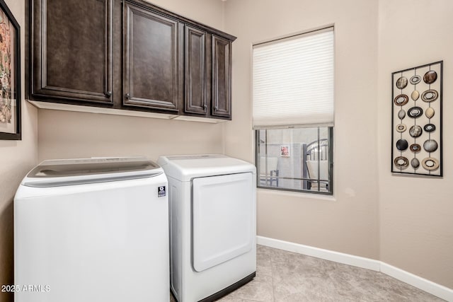 laundry area featuring cabinet space, washing machine and dryer, and baseboards