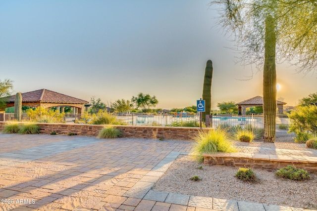 view of community featuring a gazebo, a patio, a pool, and fence