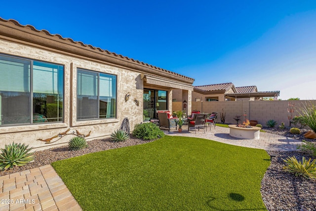 view of yard featuring a patio, a fire pit, and fence