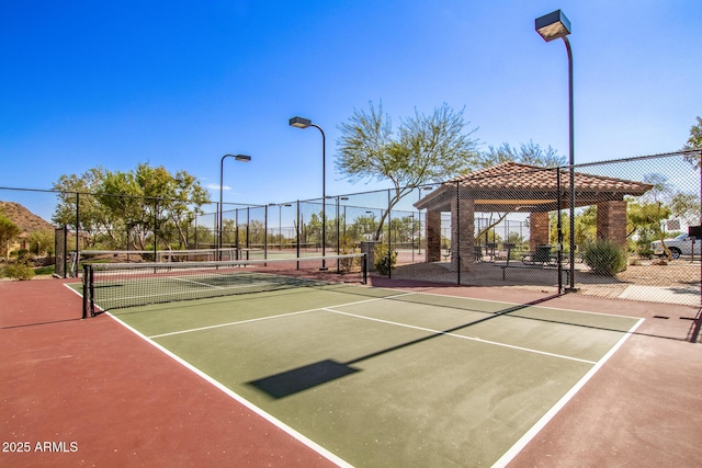 view of tennis court featuring a gazebo and fence