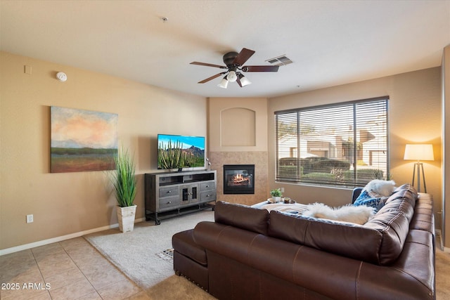 living room featuring ceiling fan, light tile patterned flooring, and a fireplace