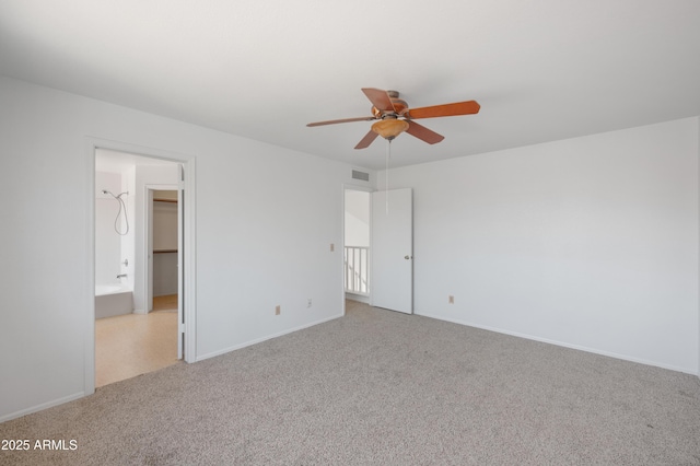 unfurnished bedroom featuring visible vents, carpet flooring, a ceiling fan, a walk in closet, and baseboards