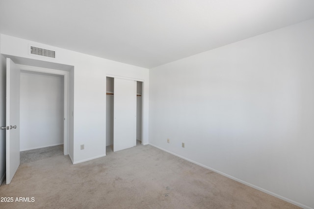 unfurnished bedroom featuring a closet, visible vents, baseboards, and light carpet
