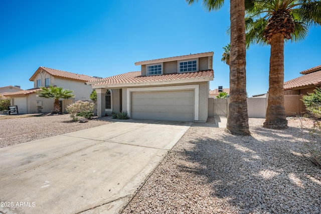 mediterranean / spanish home with driveway, fence, an attached garage, stucco siding, and a tile roof