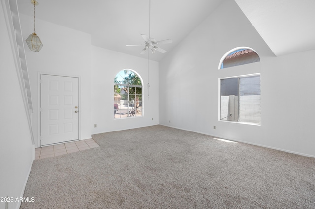 spare room with tile patterned floors, carpet, ceiling fan, and high vaulted ceiling