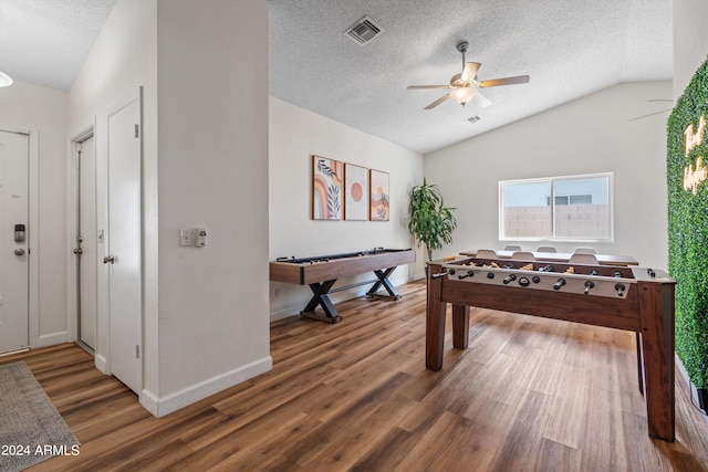 playroom featuring a textured ceiling, dark hardwood / wood-style flooring, ceiling fan, and lofted ceiling