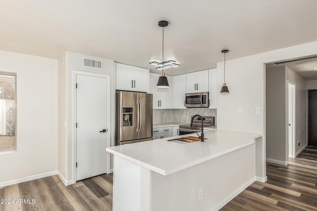 kitchen featuring sink, white cabinets, hanging light fixtures, and appliances with stainless steel finishes