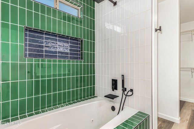 bathroom with wood-type flooring and tiled shower / bath