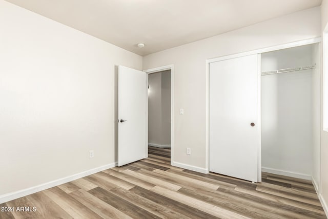 unfurnished bedroom with wood-type flooring and a closet