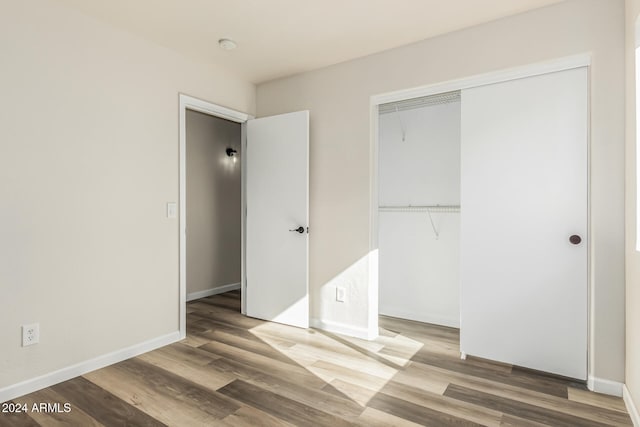 unfurnished bedroom with a closet and hardwood / wood-style flooring