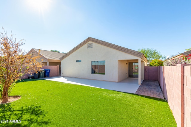 back of house featuring a lawn and a patio area