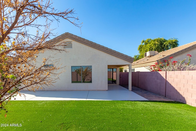 rear view of house featuring a patio area and a yard