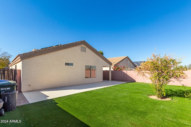 rear view of property featuring a lawn and a patio