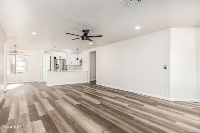 unfurnished living room featuring hardwood / wood-style floors and ceiling fan