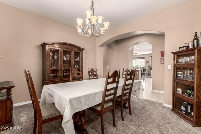 dining space with light carpet and a chandelier