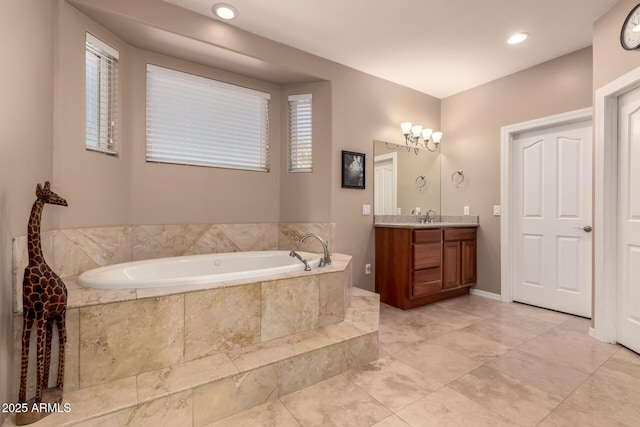 bathroom with tiled tub and vanity