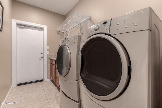 laundry room featuring cabinets, washing machine and dryer, and light tile patterned floors