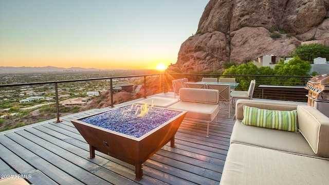 deck at dusk featuring a mountain view and a fire pit