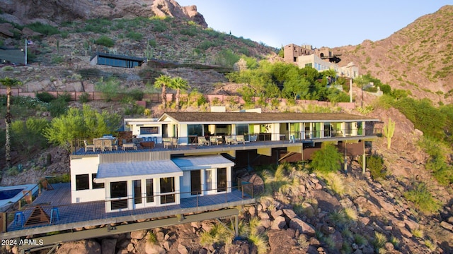 rear view of property with a mountain view and a balcony