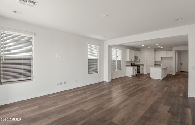 32076 N 136th Ave, Peoria, AZ 85383 - unfurnished living room featuring dark wood-style flooring, recessed lighting, baseboards, and visible vents
