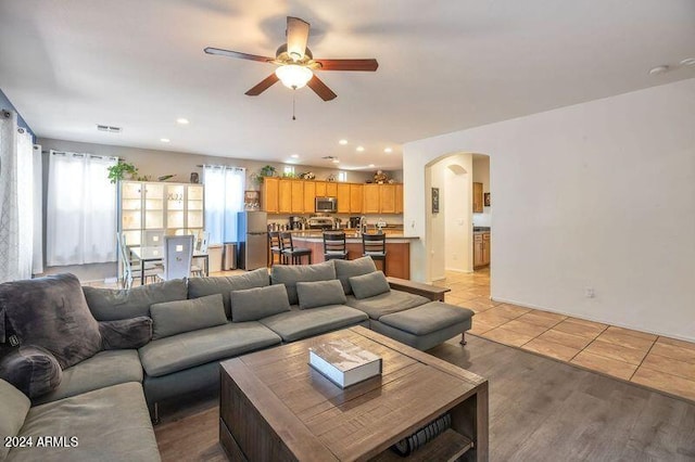 living room featuring ceiling fan and light hardwood / wood-style floors