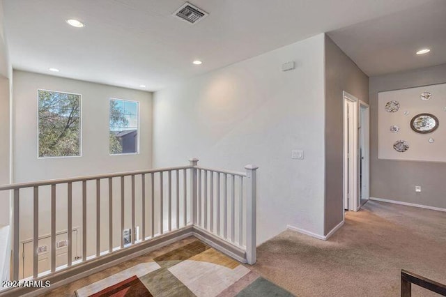 hallway featuring light colored carpet