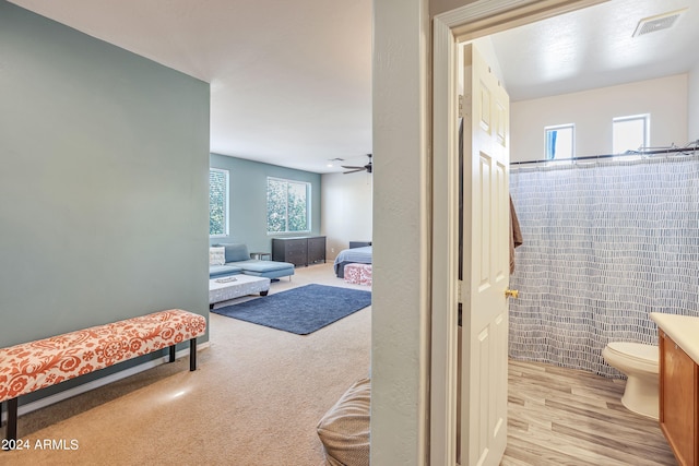 bathroom with walk in shower, ceiling fan, toilet, hardwood / wood-style floors, and vanity