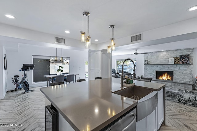 kitchen featuring dark countertops, recessed lighting, visible vents, and a stone fireplace