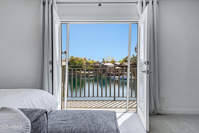 bedroom with baseboards, a water view, and carpet flooring