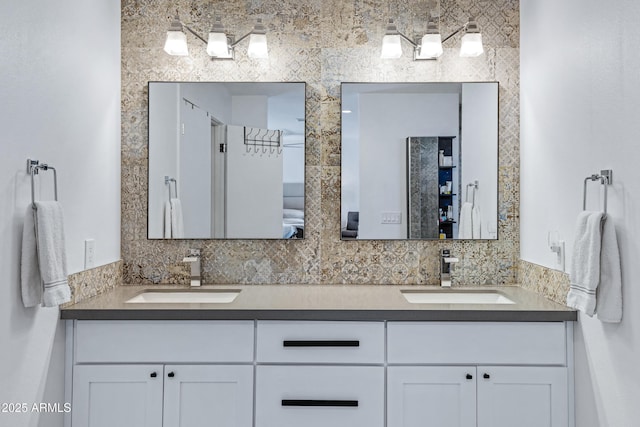 bathroom with a sink, backsplash, and double vanity