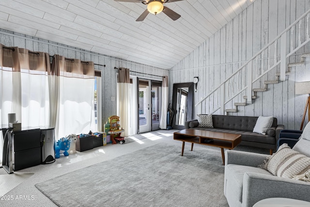 carpeted living area featuring lofted ceiling, stairway, and a ceiling fan