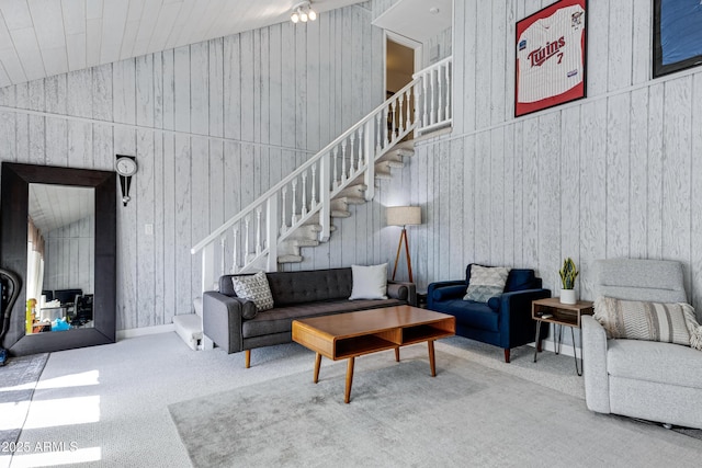 living room featuring vaulted ceiling, carpet floors, and stairs