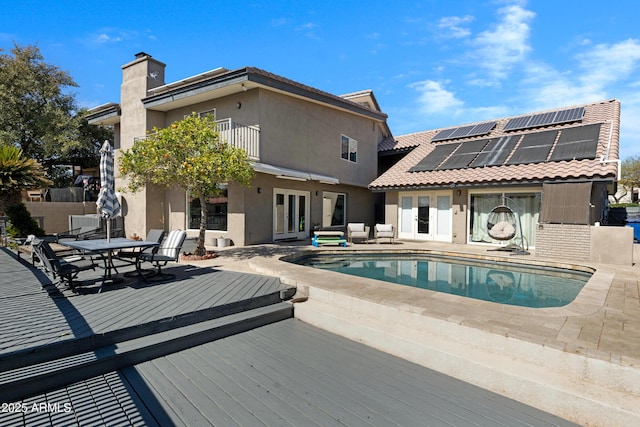 pool with french doors, outdoor dining area, outdoor lounge area, fence, and a wooden deck