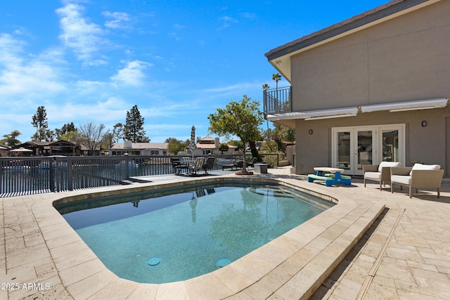 view of pool with a patio area, fence, a fenced in pool, and french doors