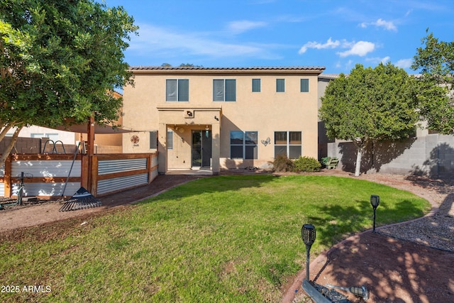 rear view of property with a lawn