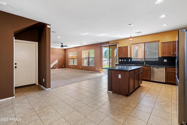 kitchen with decorative light fixtures, tasteful backsplash, light tile patterned flooring, a center island, and stainless steel appliances